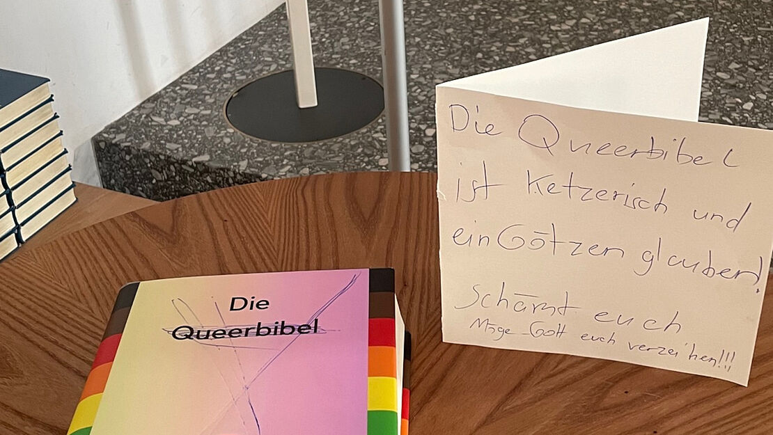 Durchgestrichener Einband der "queeren Bibel" und Schmähschrift